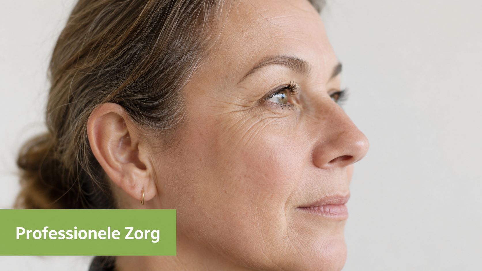 Een vrouw van middelbare leeftijd met natuurlijke tekenen van veroudering op haar gezicht kijkt opzij.