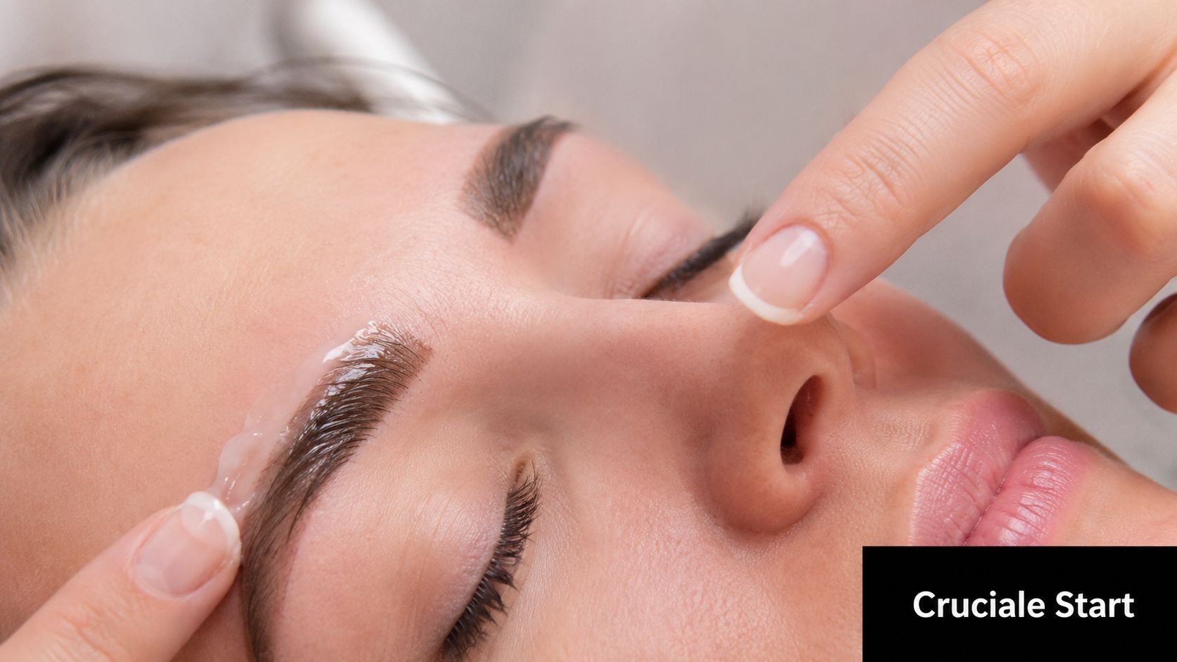 Een schoonheidsspecialiste brengt een verzorgende lotion aan op de wenkbrauwen voor een professionele permanente make-up behandeling.