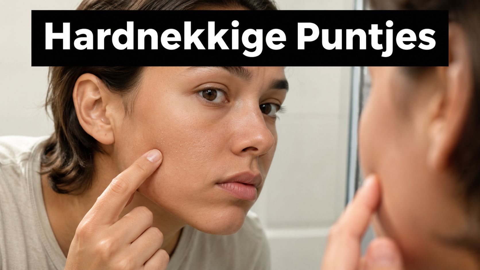 Een jonge vrouw die in de spiegel kijkt en naar kleine witte puntjes op haar gezicht wijst.